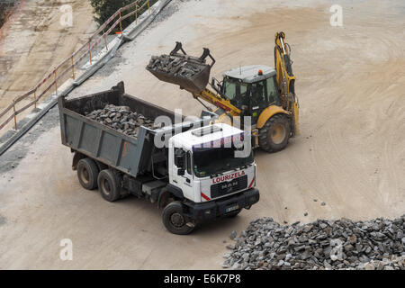 Luftaufnahme des Baggers laden Felsen auf Muldenkipper auf einer Baustelle Stockfoto