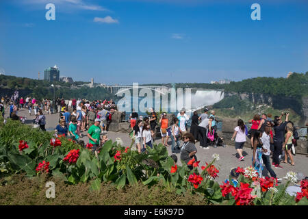 Touristen, die in Niagara Falls, Ontario, Kanada. American Falls und die Rainbow Bridge. Stockfoto