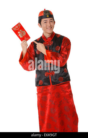 Junger Mann in der chinesischen traditionellen Kleidern mit roten Umschlägen feiert Chinesisches Neujahr Stockfoto