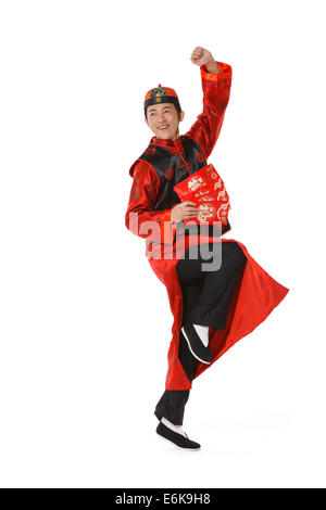 Junger Mann in der chinesischen traditionellen Kleidern mit roten Umschlägen feiert Chinesisches Neujahr Stockfoto