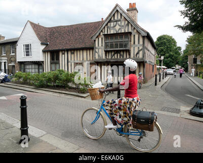 Frau Radfahrerin, die mit dem Fahrrad an der Orford Road und dem Ancient House im Walthamstow Village London vorbeifährt, London UK KATHY DEWITT Stockfoto