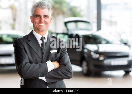 zuversichtlich senior Auto Händler wichtigsten stehen im showroom Stockfoto