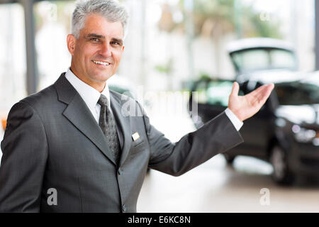 schöne ältere Fahrzeug Verkäufer Neuwagen im Showroom präsentiert Stockfoto