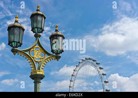 Eine dekorative Straßenleuchte auf Westminster Bridge mit dem London Eye im Hintergrund, vor blauem Himmel. Stockfoto