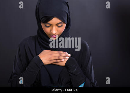 geheimnisvolle Muslimin beten auf schwarzem Hintergrund Stockfoto