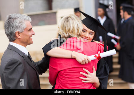 glücklich weibliche Absolventin umarmt ihre Mutter nach dem Studium Stockfoto