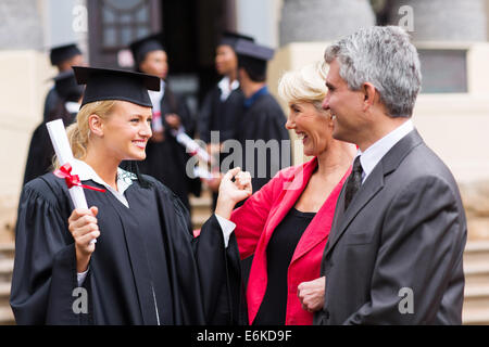 glücklich weibliche Hochschulabsolvent mit Eltern bei Abschlussfeier Stockfoto