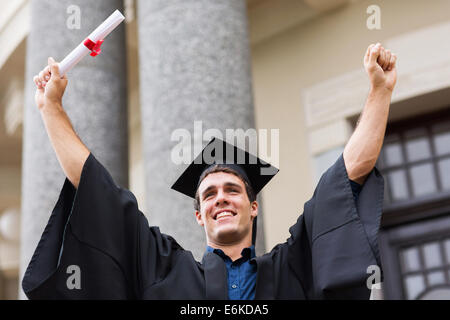 erfolgreiche männliche Hochschulabsolvent nach dem Studium Stockfoto