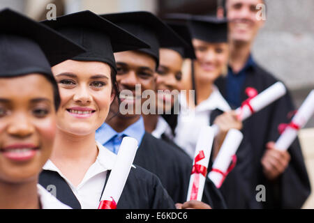 Gruppe von glücklich College-Absolventen stehen in einer Reihe Stockfoto