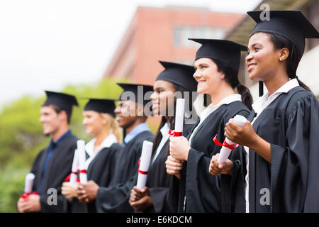 Gruppe von Rassen Hochschulabsolventinnen und-Absolventen bei Abschlussfeier Stockfoto