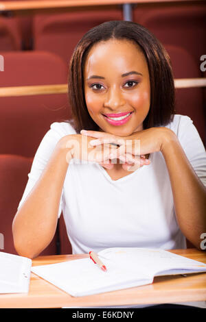 schöne junge afroamerikanische Mädchen sitzen im Klassenzimmer Stockfoto