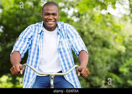 fröhlichen afrikanischen Mann Spaß mit dem Fahrrad im Wald Stockfoto