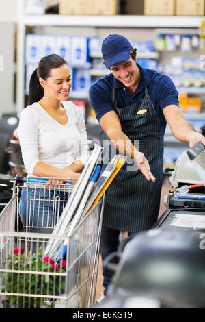 Supermarkt Arbeiter Hilfe Kundin beim Kauf Bbq grill Stockfoto