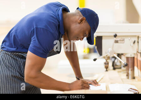 junge afrikanische Tischler arbeiten in Werkstatt Stockfoto