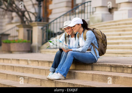 zwei schöne weibliche Touristen auf der Suche auf Karte Stockfoto