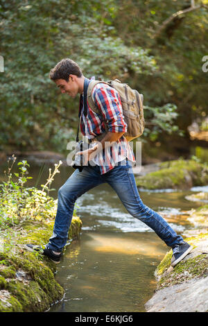 junge Fotografen Kreuzung Wasserstrom im Bergtal Stockfoto