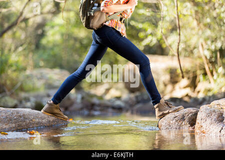 junge weibliche Wanderer Kreuzung Stream in Berg Stockfoto