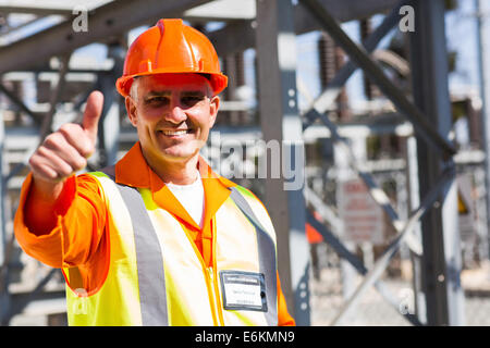 mittleren Alter Elektriker Daumen aufgeben im Umspannwerk Stockfoto