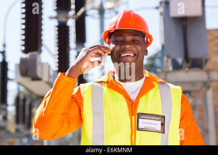 glücklich afrikanische Elektriker mit Handy in elektrische Unterstation Stockfoto