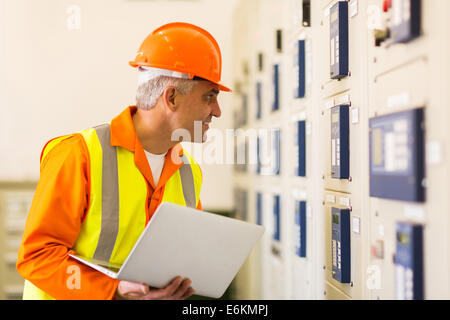 mittleren Alter Industrieelektriker arbeiten im Kraftwerk Leitwarte Stockfoto