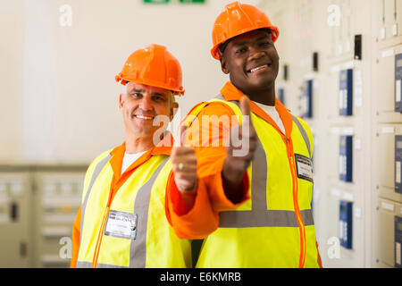 fröhliche Elektroingenieure Daumen aufgeben Stockfoto