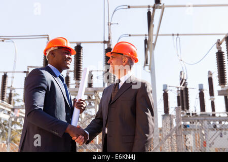 zwei fröhliche Geschäftsmann Handshaking in elektrische Unterstation Stockfoto