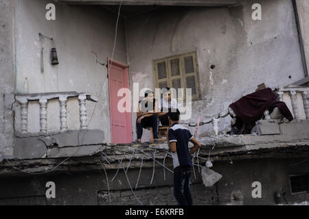 Gaza. 26. August 2014. Palästinensische Kinder sitzen auf den Ruinen einer Wohntürme, zerstört durch die israelische Luftwaffe in Gaza-Stadt, Sanitäter sagte, dass die Streiks zerstört zwei Wohntürme, zwei Komponenten der Dutzende von Böden, Verwundung zwanzig Bürger und die Vertreibung von Hunderttausenden Familien, und der Krieg gegen Gaza für den Tag 51 in die Bemühungen der internationalen der arabischen und der Waffenstillstand zwischen den beiden Parteien palästinensischen und israelischen , aber alle Versuche fehlgeschlagen. Bildnachweis: Ibrahim Khader/Pacific Press/Alamy Live-Nachrichten Stockfoto