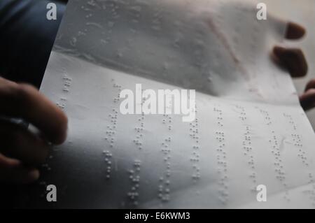 Blinder Mann von einer Seite geschrieben in Blindenschrift lesen Stockfoto