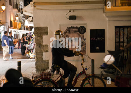 Maskierte Frau auf Fahrrad in den Gassen der Altstadt von Ibiza - Ibiza Stockfoto