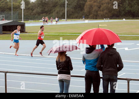 Leichtathletik-Zuschauer mit Sonnenschirmen Stockfoto