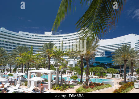 LIEGESTÜHLE AM POOL FONTAINEBLEAU HOTEL („MORRIS LAPIDUS 1954") MIAMI BEACH FLORIDA USA Stockfoto