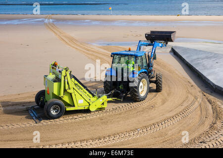 Badestrand Meer in Redcar gereinigt von den örtlichen Behörden über eine mechanische Traktor gezogen Maschine Arber Surf Rake Stockfoto