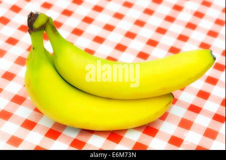 Zwei Bananen auf einem rot karierten Hintergrund Stockfoto