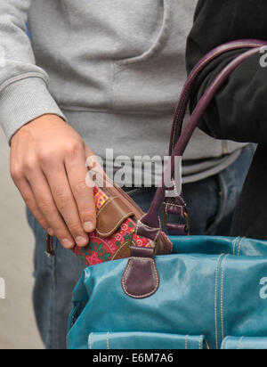 Dresden, Deutschland. 21. August 2014. ILLUSTRATION - ein Mann stiehlt eine Geldbörse aus einer Frau die Handtasche in der Straßenbahn und Bus Station in Dresden, Deutschland, 21. August 2014. Foto: ARNO BURGI/Dpa/Alamy Live-Nachrichten Stockfoto