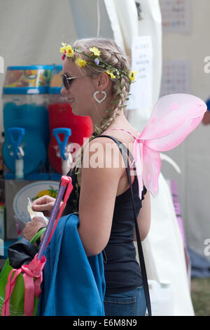 eine junge Frau mit Engel Flügel Warteschlangen für ein kühles Getränk an der siegreichen Festival 2014 Southsea England uk Stockfoto