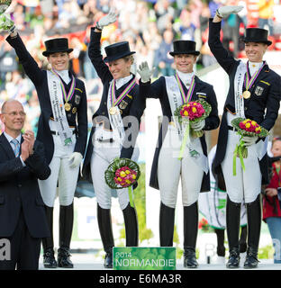 Caen, Frankreich. 26. August 2014. Deutsche Dressurmannschaft Kristina Sprehe (l-R), Helen Langehanenberg, Isabell Werth und Fabienne Luetkemeier gewann die Goldmedaille mit Ausrüstung-Chef Klaus Roeser auf der linken Seite bei den World Equestrian Games in Caen, Frankreich, 26. August 2014 feiern. Team-Coach Klaus Roeser steht auf der linken Seite. Foto: ROLF VENNENBERND/Dpa/Alamy Live News Stockfoto