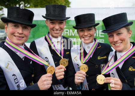 Caen, Frankreich. 26. August 2014. Deutsches Dressur-Team Sabell Werth (l-R), Fabienne Luetkemeier, Kristina Sprehe und Helen Langehanenberg feiern Gewinn der Goldmedaille bei den World Equestrian Games in Caen, Frankreich, 26. August 2014. Foto: ROLF VENNENBERND/Dpa/Alamy Live News Stockfoto