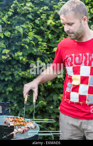 Mann, Kochen von Fleisch auf dem Grill - rechts Stockfoto