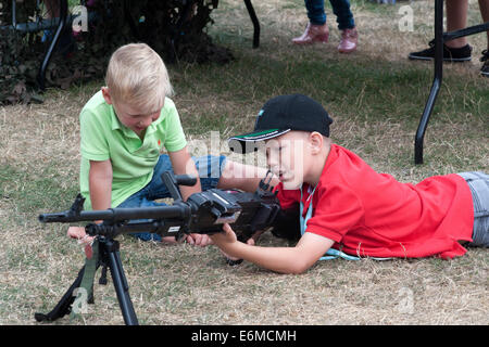 zwei Jungen spielen mit einem deaktivierten Gewehr auf einen Stand auf der siegreichen Festival 2014 Southsea England uk Stockfoto