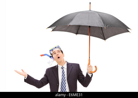 Geschäftsmann mit Tauchmaske mit Regenschirm Stockfoto