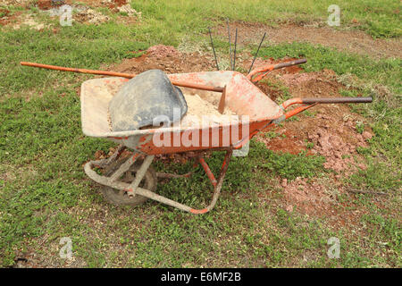 alten Schubkarre mit Sand und Ausrüstung für den Bau Stockfoto