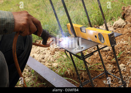 elektrisches Schweißen, Metall-Stab und Metallplatte mit Pegelanzeige verbinden Stockfoto