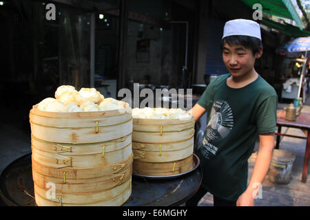 Eine junge chinesische muslimische verkauft gedämpfte Brötchen in der muslimischen Viertel Nachbarschaft von Xi ' an, China. Stockfoto