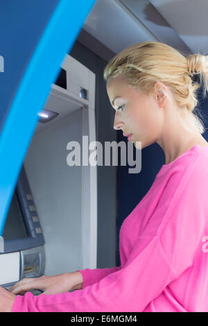 Dame mit einem atm-Zähler Stockfoto