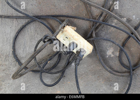 Alte weiße Kunststoff Erweiterung Adapter Kabel auf dem Boden Stockfoto