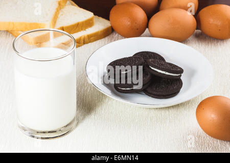 Gesunde Ernährung mit frischer Milch, Schokoladenkekse, Eiern und Brot Stockfoto