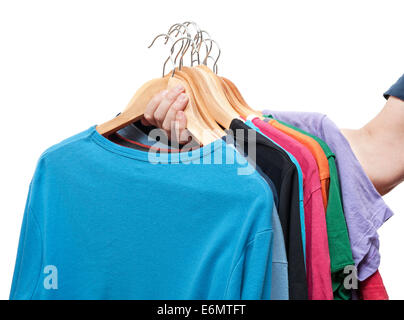 Männer Hand halten Kleiderbügel mit Pullover und t-shirts Stockfoto