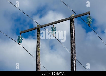 Alte elektrische Holzpfosten gegen blauen Himmel und schöne Wolken Stockfoto