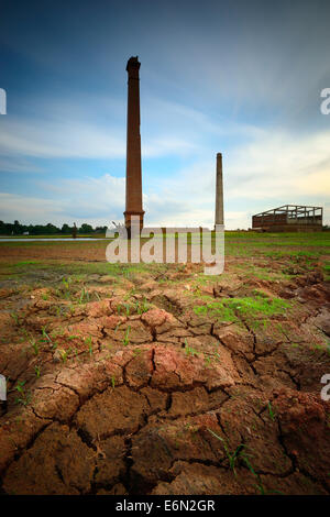 Alten verfallenden Fabrikgebäude mit Spiegelungen im See Stockfoto