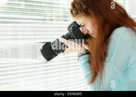 Frau, die ein Foto durch ein Fenster Stockfoto